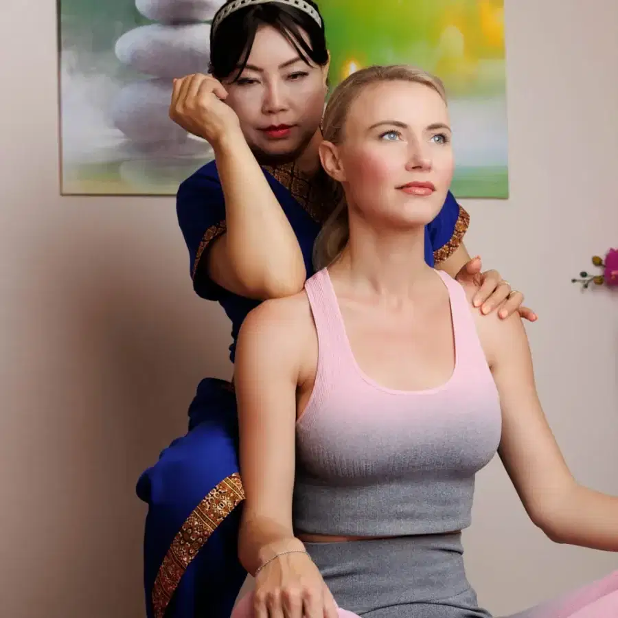 Therapist applying deep pressure to a client's shoulder using her elbow.